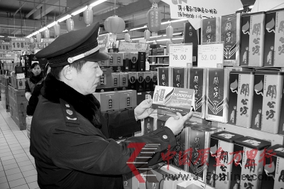 　　工商人員正在檢查“過期”促銷牌。 通訊員 華俊 文軍 攝